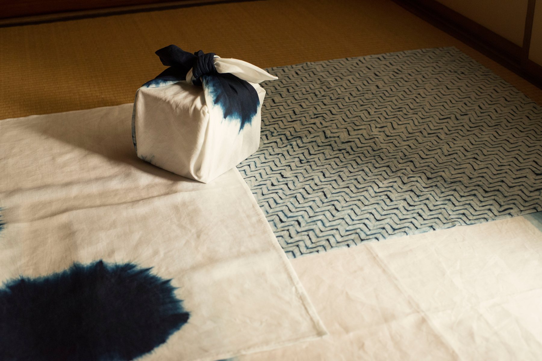 Furoshiki-wrapped box on indigo shibori cloths over tatami