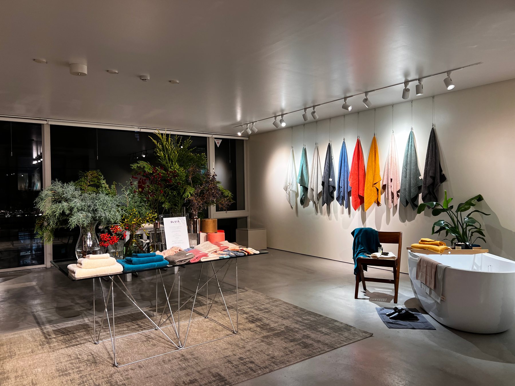 Showroom with towels hung along the wall and a freestanding bath