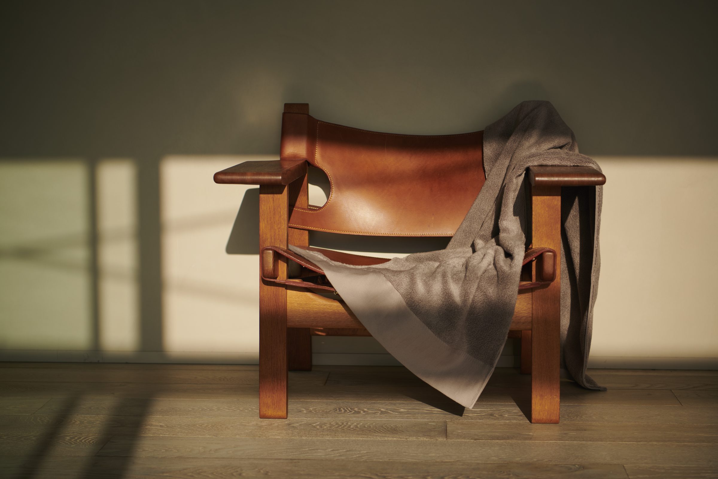 A towel draped over a leather chair in late light