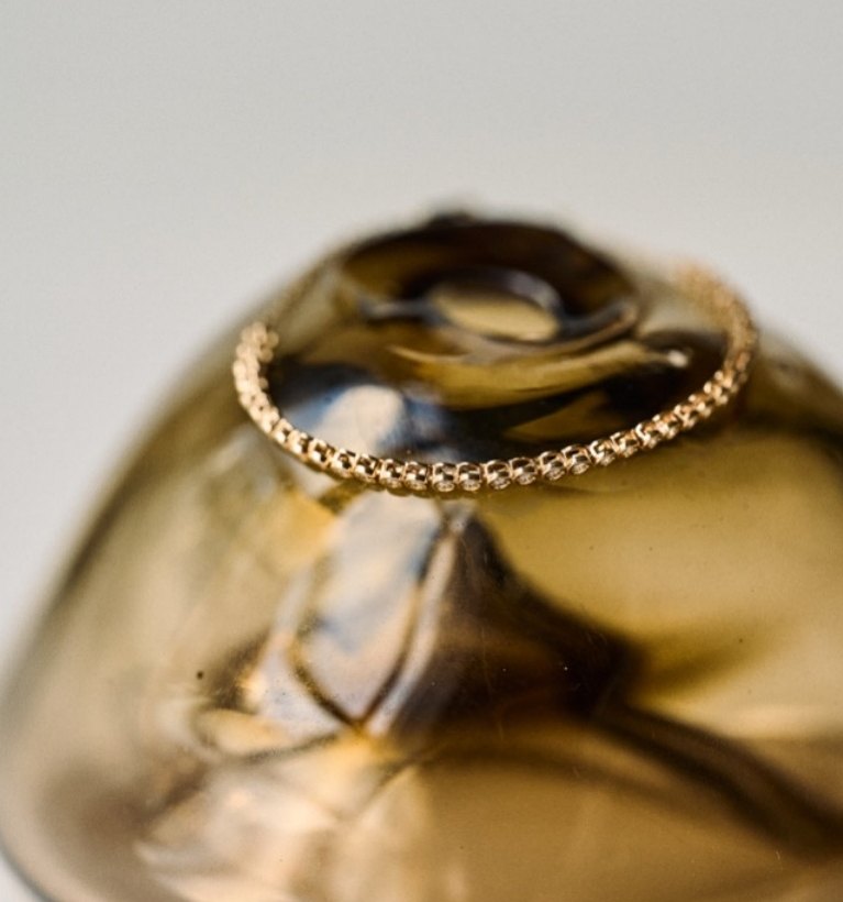 Gold chain bracelet on amber glass