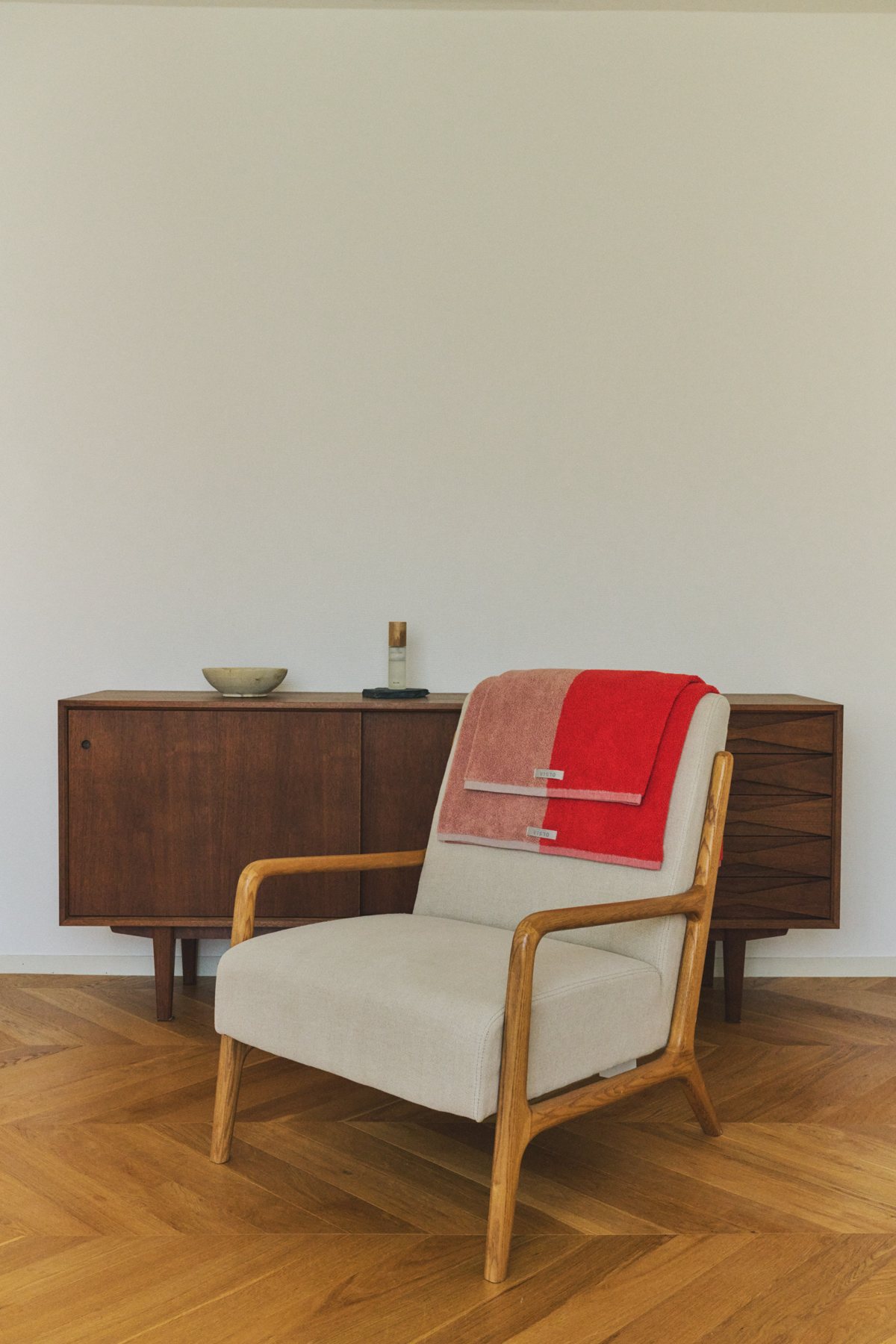 Two-tone towels draped over a linen armchair