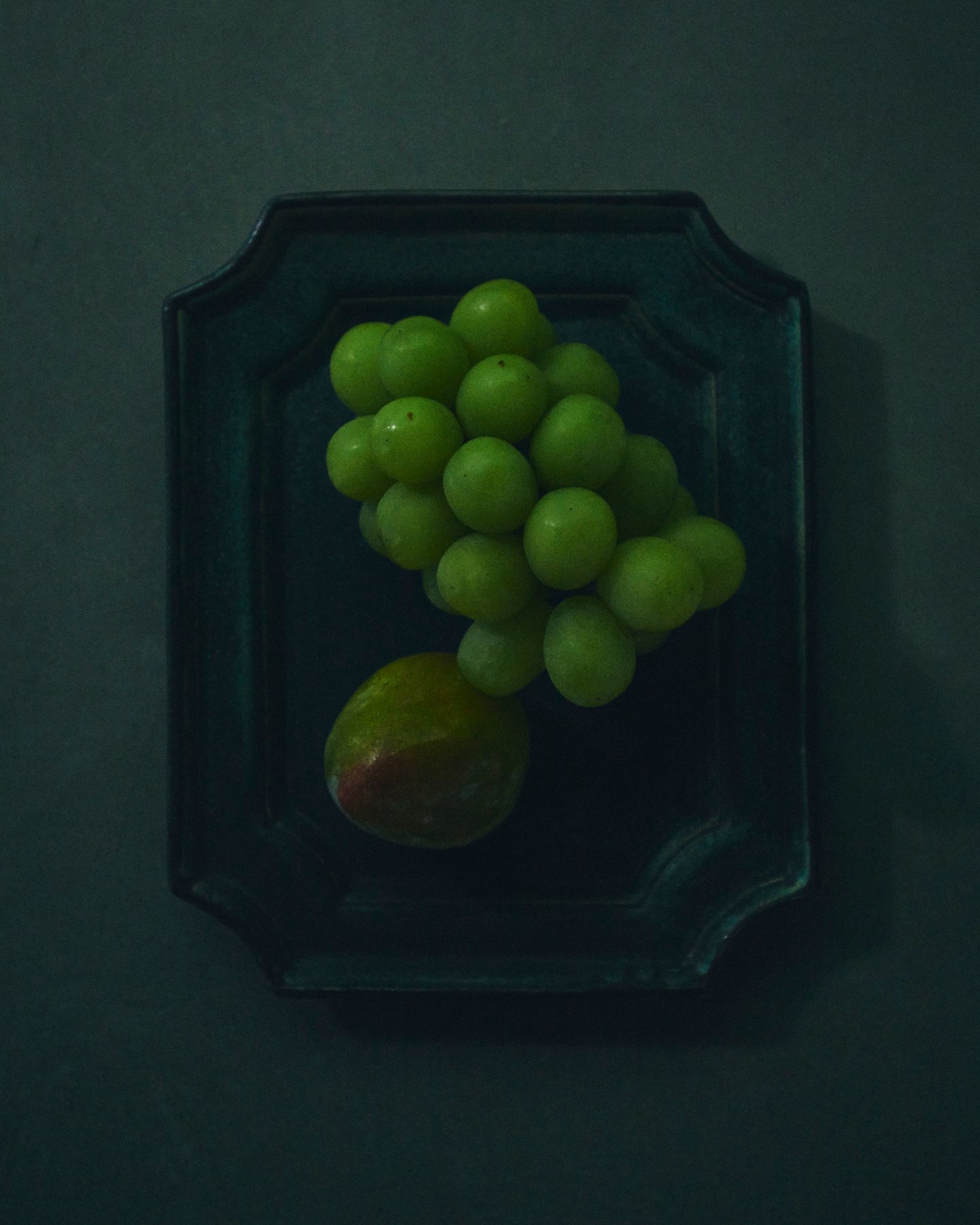 Green grapes on a dark ceramic plate