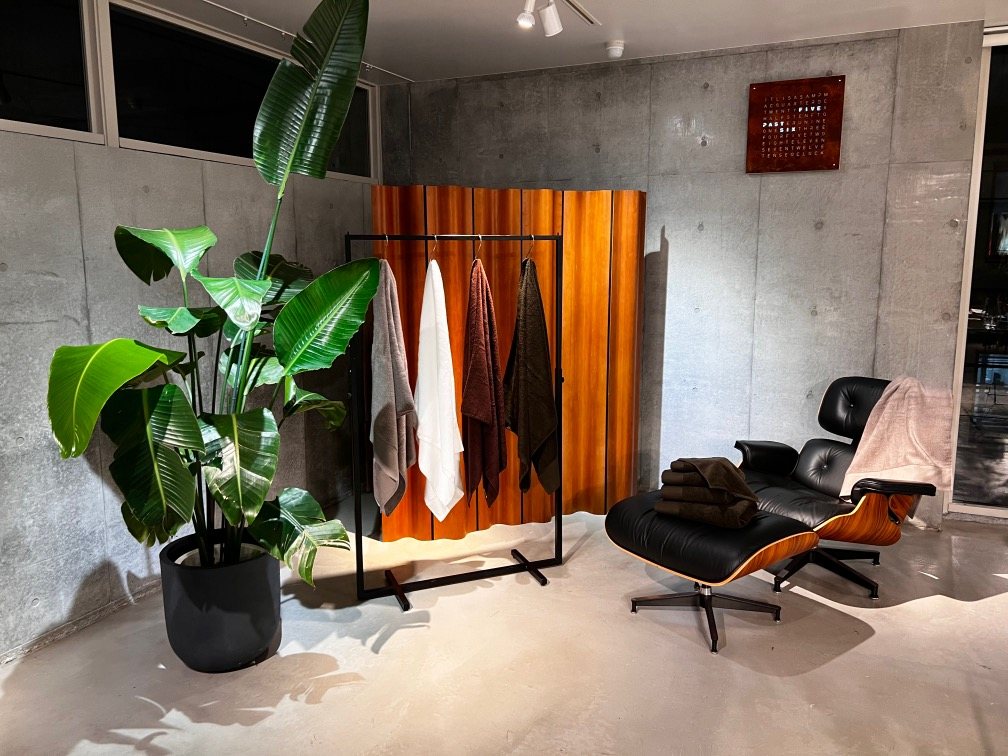 Showroom corner with towels on a rack beside a lounge chair