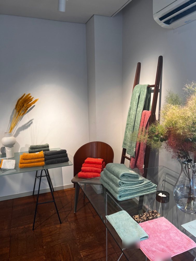 Towels displayed on a glass table, wooden ladder and stool
