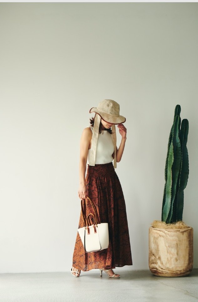 Woman with a white bag beside a cactus