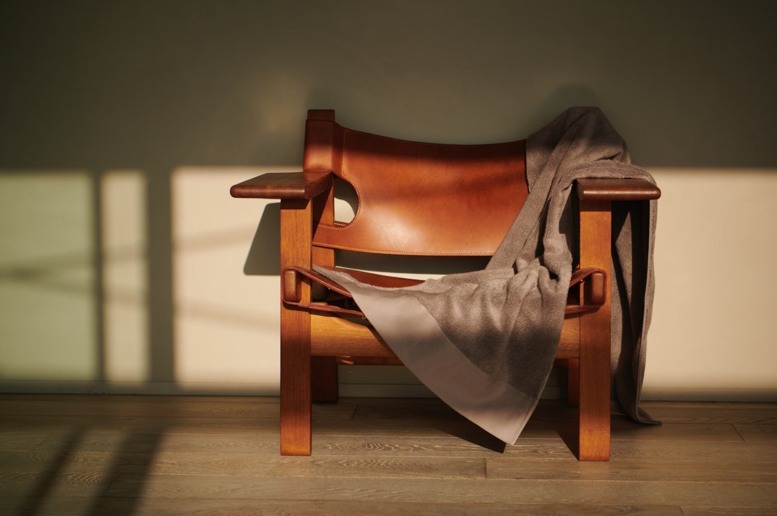 Grey towel draped over a leather armchair in evening light
