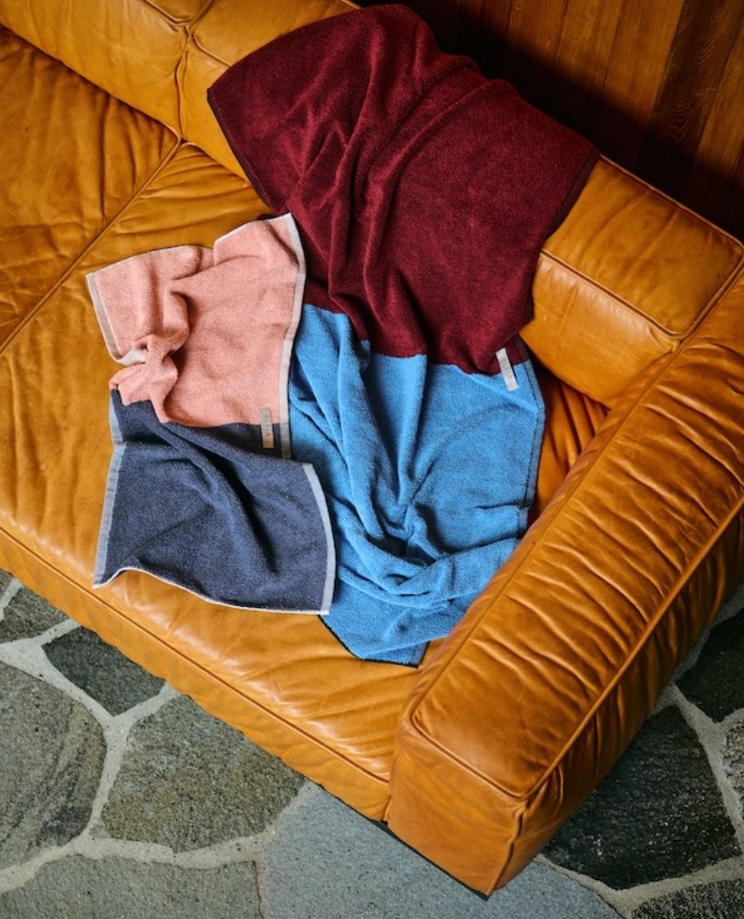 Coloured towels tossed on a leather sofa