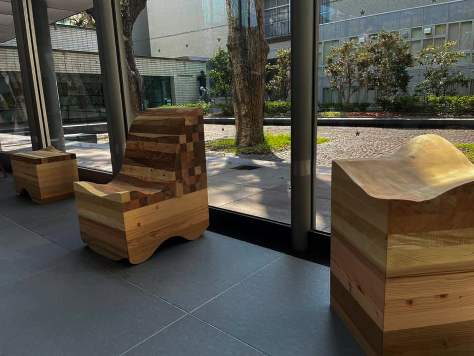 Wooden chairs and stools with carved seats by the museum window